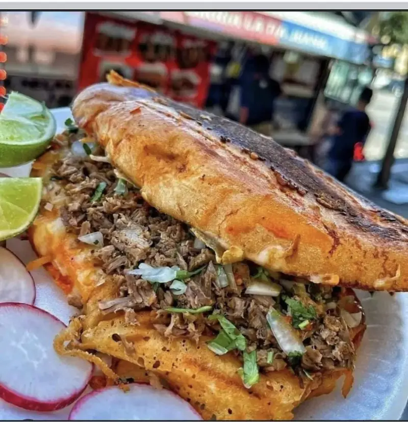 Torta filled with meat, served with limes and radishes